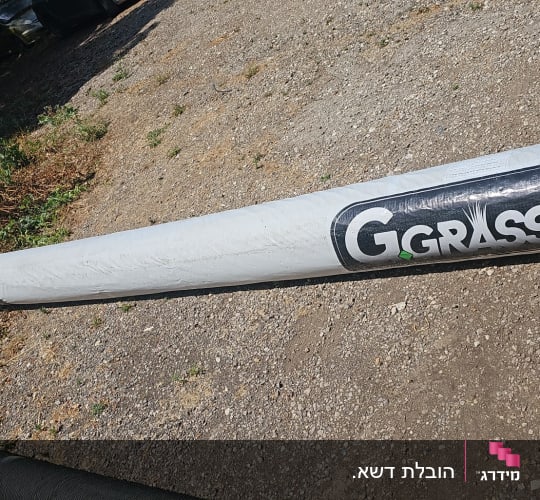 גליל דשא סינתטי עם כיתוב GGGRASS על הקרקע